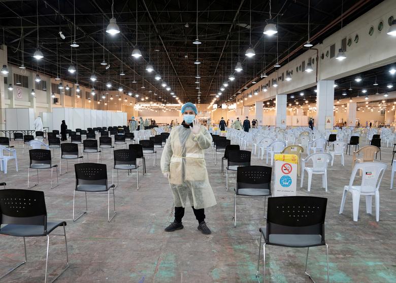 Кувейт. Волонтер направляет посетителей в центр, где делают массовое тестирование на коронавирус на территории Кувейтского международного выставочного центра / март 2020 / Reuters