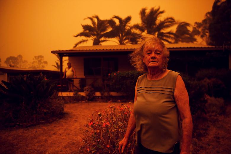 Австралія. Ненсі та Браян Аллени стоять поруч зі своїм будинком, котрий огорнув смог від пожеж в Австралії / січень 2020 року / Reuters
