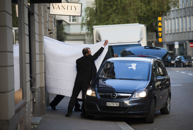Заарештованих керівників ФІФА виводять з готелю в Цюриху, прикриваючи простирадлами. Фото The New York Times 