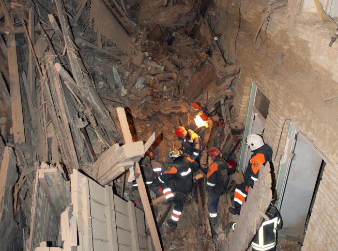 В Киеве спасатели пробиваются к находящимся под завалами дома трем строителям