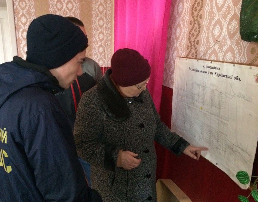 Сельский голова Лидия Леонидовна показывает карту села активистам, которые собираются на патрулирование. Фото: «Ракурс»