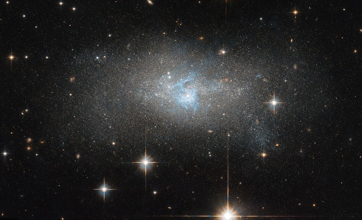 Изображение космического телескопа Хаббл показывает ярко-синий газ, который пронизывает галактику IC 4870. Газ светится, поскольку излучает радио- и гамма-волны