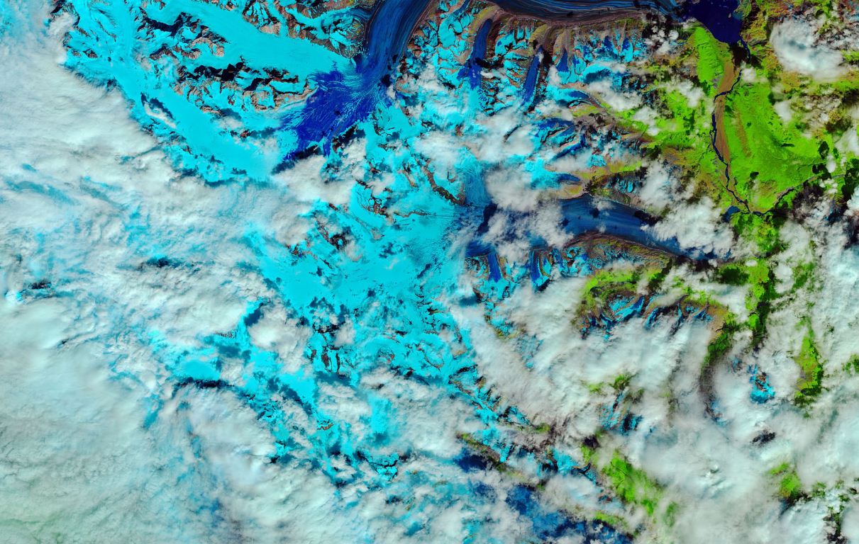  Сніг з попередньої зими, який тане на льодовику Лоуелл у Канаді. Заморожені ділянки зображені світло-блакитним кольором, талі води — темно-синім, гори — коричневим, а рослинність — зеленим
