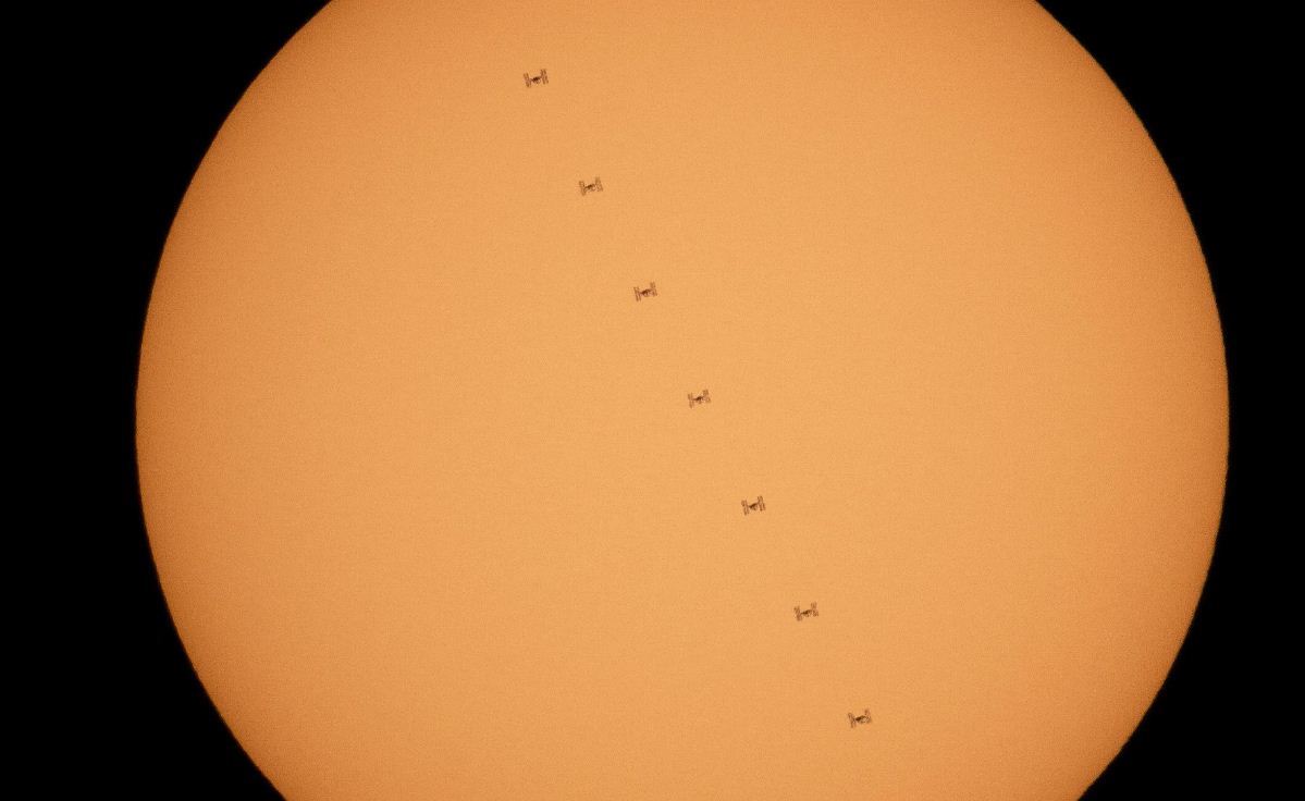 Изображение, составленное из девяти кадров, показывает силуэт Международной космической станции, которая проходит через Солнце со скоростью 8 км/ч