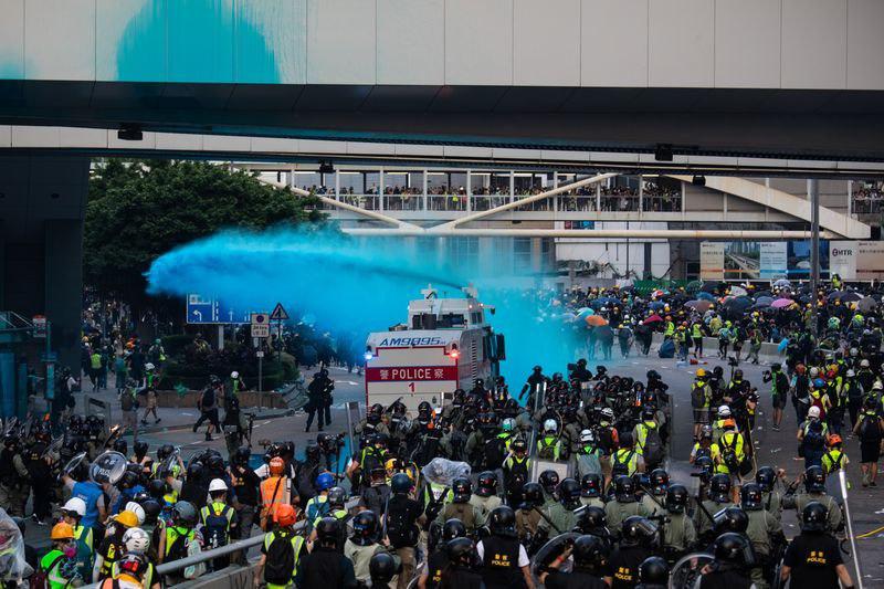Протесты в Гонконге: автомобиль с водяной пушкой распыляет синий краситель, чтобы разогнать демонстрантов в Адмиралтейском районе. Фото: Кайл Лам / Bloomberg