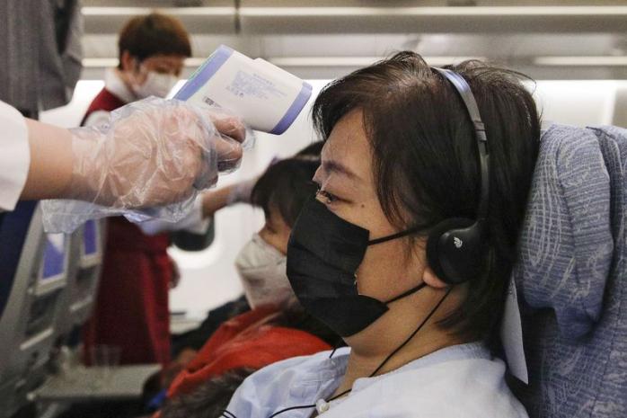 В Украине пассажирам авиарейсов измеряют температуру из-за коронавируса. Фото: AP Photo/Andy Wong