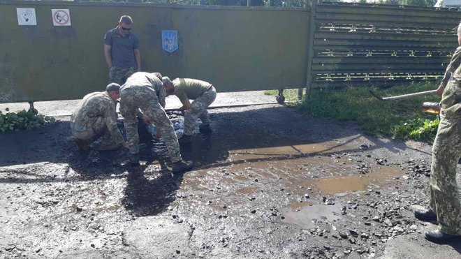 Воду из луж перед визитом Зеленского выгребали военные на Волыни. Фото: 24 канал