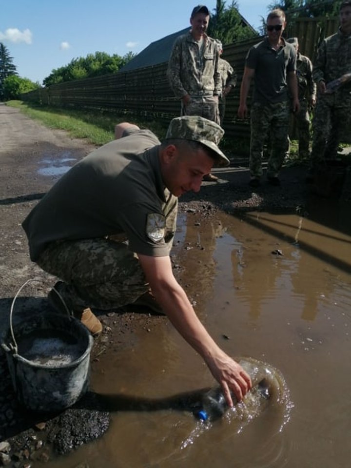 Воду из луж перед визитом Зеленского выгребали военные на Волыни. Фото: 24 канал