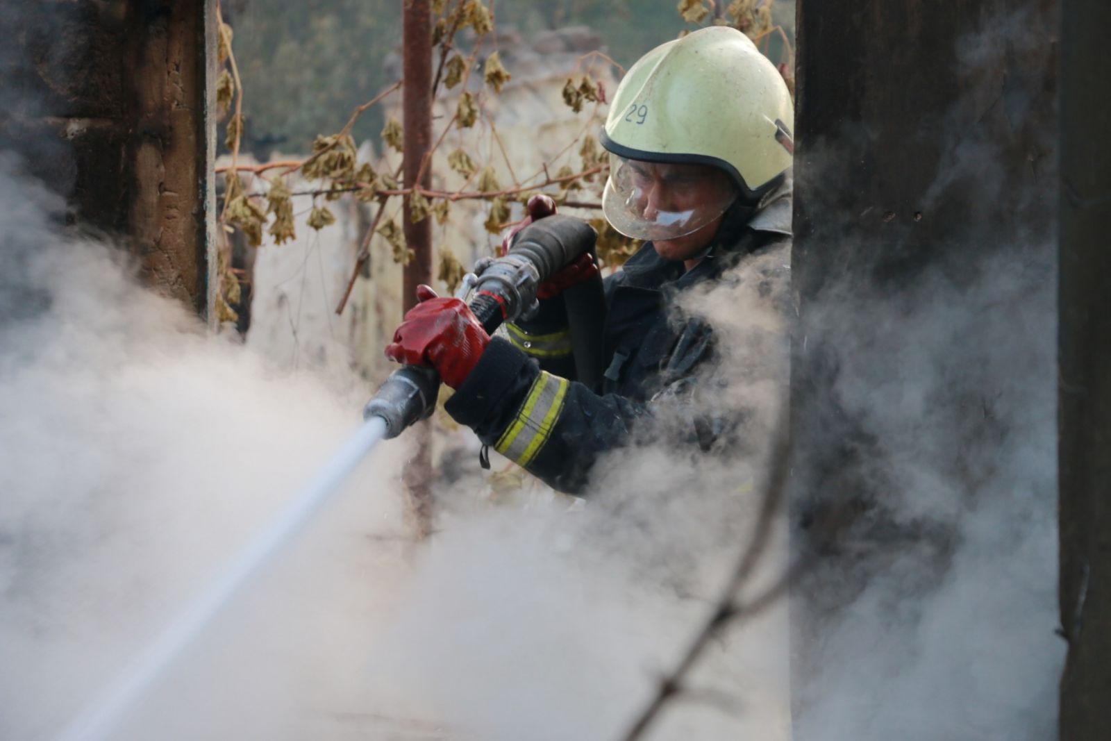 Пожарник тушит древесину. Фото: пресс-служба ГСЧС