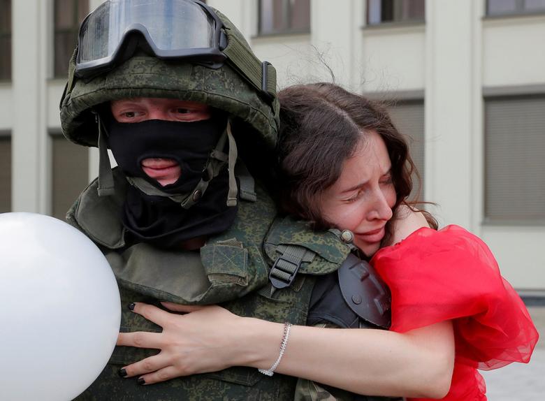 Білорусь. Протестувальниця обійняла працівника правоохоронних органів під час акції проти Лукашенка у Мінську / серпень 2020 року / Reuters
