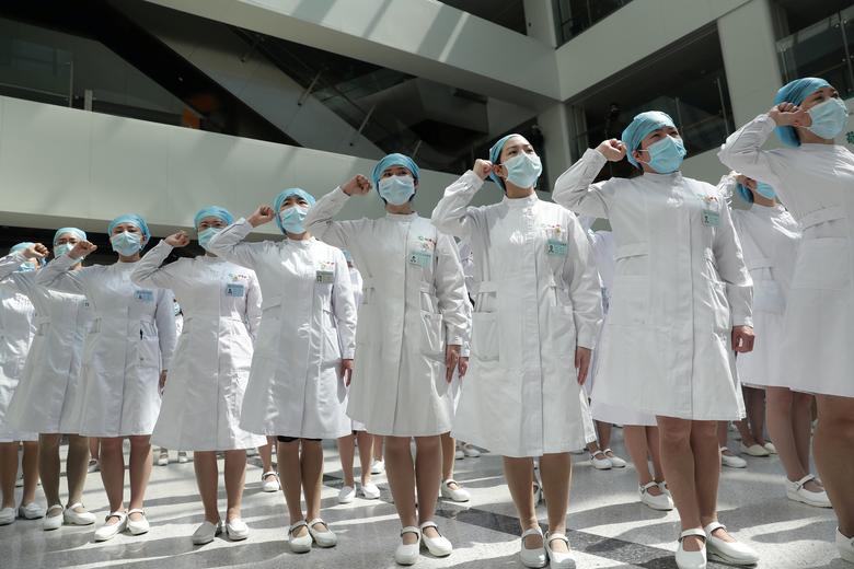 Китай. Медсестры в масках участвуют в мероприятии, посвященному Международному дню медсестер в госпитале Уханя / май 2020 / Reuters