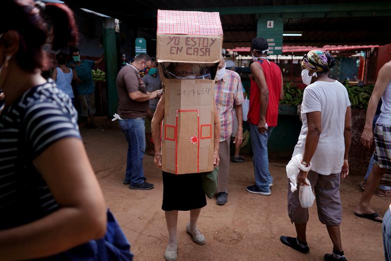Куба. 82-летняя медсестра на пенсии Феридиа Ройяс самостоятельно сделала себе картонную защиту от коронавируса / июнь 2020 / Reuters