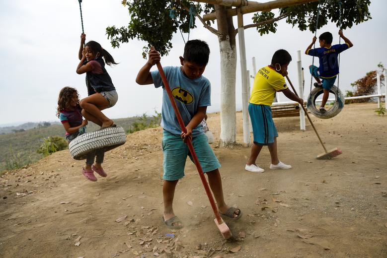 Эквадор. Дети убирают детскую площадку после прекращения обучения из-за коронавируса. 16-летний ученик близ дерева читает уроки другим детям, не имеющим возможности подключиться к онлайн-обучению в бедном регионе Эквадора / июль 2020 / Reuters