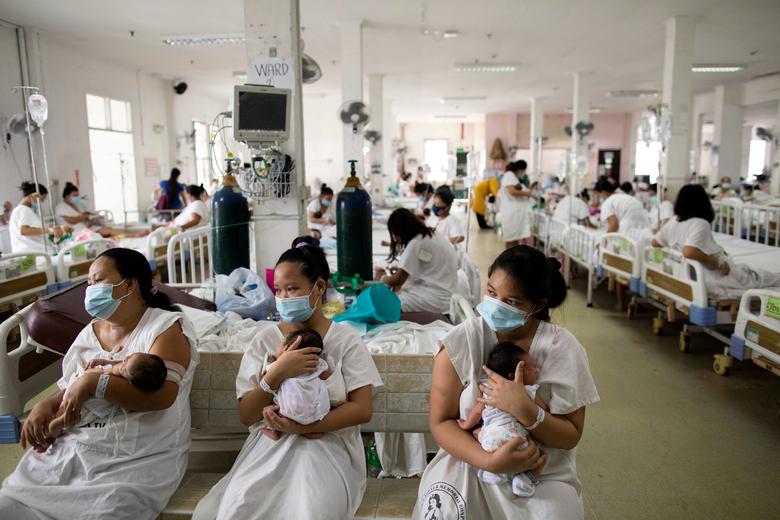 Филиппины. Матери держат своих новорожденных перед медосмотром в роддоме в разгар пандемии коронавируса / сентябрь 2020 / Reuters