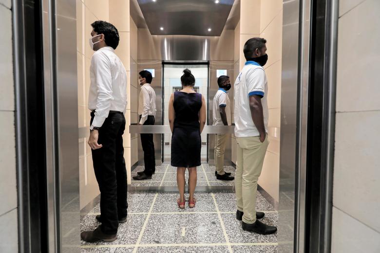Шрі-Ланка. Люди практикують соціальне дистанціювання у ліфті міжнародного торгового центру після того, як компаніям було дозволено повернутися до роботи в офісах / травень 2020 року / Reuters