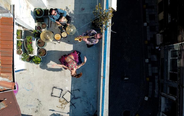 Турция. Танцовщица вместе с друзьями-музыкантами развлекают соседей на террасе своего дома во время коронавирусного карантина / апрель 2020 / Reuters