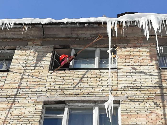 Альпинисты сбивают сосульки со зданий в Киеве. Фото: КГГА