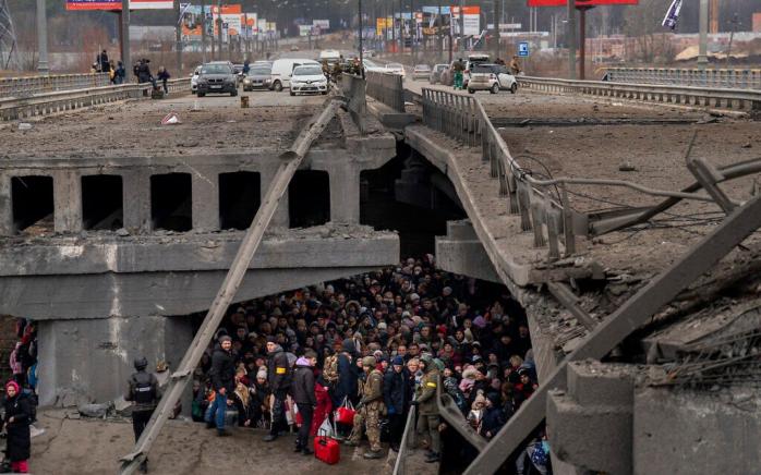 Люди ховаються від обстрілів російської авіації під розбомбленим мостом в Ірпені