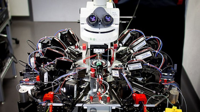 Десять «щупів» для відстеження глибокого сну. Цей «усміхнений» мікроскоп оснащений десятьма скляними піпетками, якими можна керувати з точністю до нанометра за допомогою роботизованих рук. Він може стимулювати і зчитувати електричну активність такої ж кількості нервових клітин у підключених тканинах, фото: Charité | Franz Xaver Mittermaier